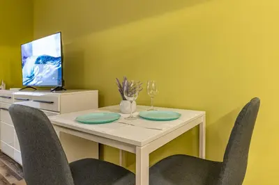 a dining room with a table with chairs and a tv at Ishirkov Residence One Bedroom Apartment in Sofia