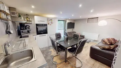 a kitchen and living room with a table and a couch at Cozy 1BR Flat next to NDK with Private Patio in Sofia