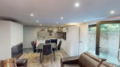 a kitchen and living room with a table and a couch at Cozy 1BR Flat next to NDK with Private Patio in Sofia