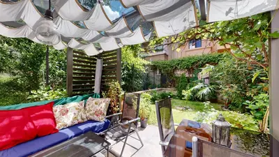 a patio with a couch and an umbrella at Cozy 1BR Flat next to NDK with Private Patio in Sofia