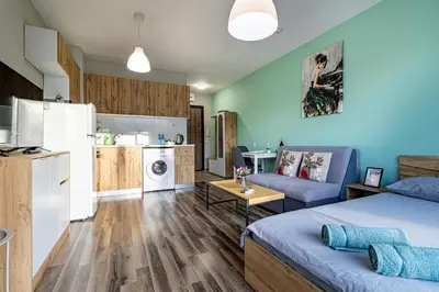 a living room with a bed and a kitchen at Ishirkov Residence Studio With Mountain VIew Balcony and Underground Parking in Sofia