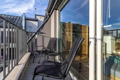 a balcony with two chairs and a window at Ishirkov Residence Studio With Mountain VIew Balcony and Underground Parking in Sofia