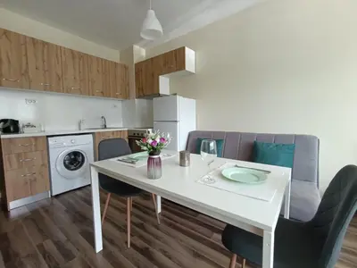 a kitchen with a white dining table and chairs at Ishirkov Residence Studio 2 in Sofia
