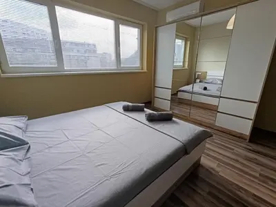 a bedroom with a large bed and a mirror at Ishirkov Residence Studio 2 in Sofia
