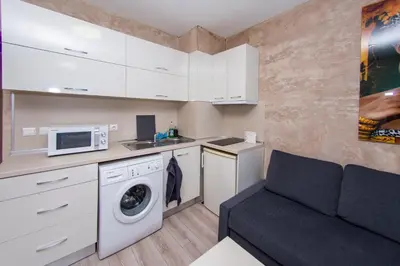 a small kitchen with a washing machine and a couch at Easy studios in Sofia