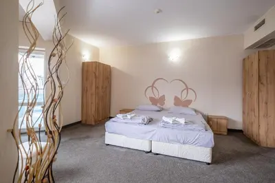 a bedroom with a bed with white sheets and wooden cabinets at Yubim rooms in Sofia