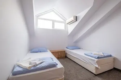 two beds in a room with a window at Yubim rooms in Sofia
