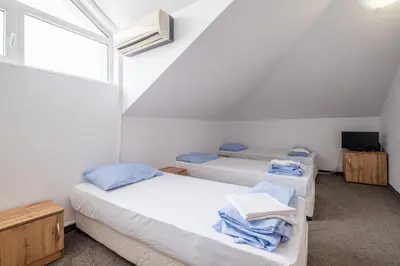two beds in a room with a window at Yubim rooms in Sofia