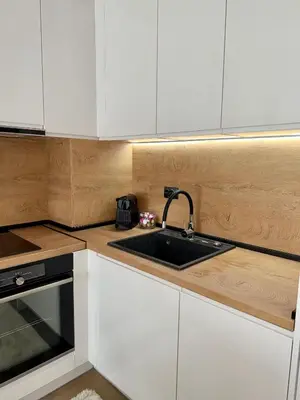 a kitchen with white cabinets and a sink at Selena Apartment 50m to Metro with Free Parking in Sofia