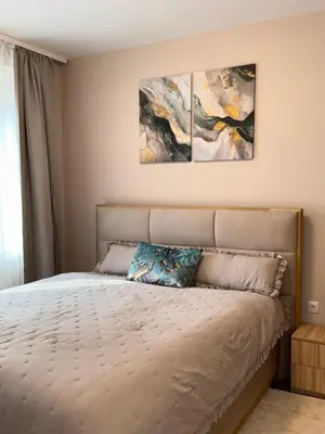 a bedroom with a bed with two paintings on the wall at Selena Apartment 50m to Metro with Free Parking in Sofia