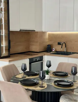 a kitchen with a table with plates and wine glasses at Selena Apartment 50m to Metro with Free Parking in Sofia