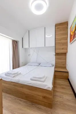 a bedroom with a large bed with white sheets at Elena apartment in Sandanski