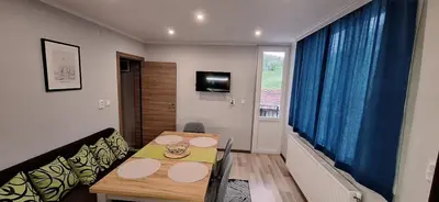 a room with a table and a couch and a television at Stoykite view in Stoykite
