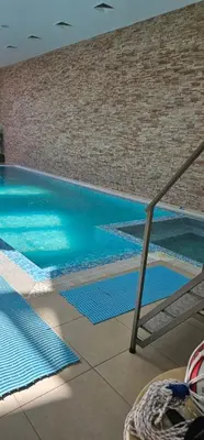 a swimming pool with blue water in a building at Аспен голф ризорт F204 in Razlog