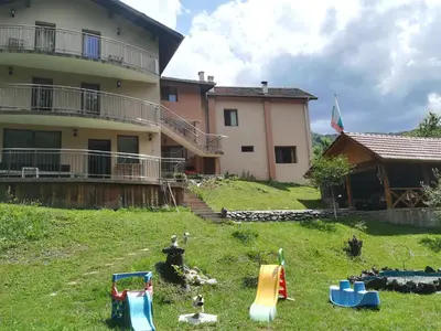 a house with a yard with toys in the grass at Villa Bulgarka in Divchovoto