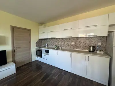an empty kitchen with white cabinets and a sink at 63rd Luxury One Bedroom Apartment in Sofia