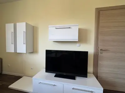 a living room with a tv and white cabinets at 63rd Luxury One Bedroom Apartment in Sofia