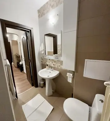 a white bathroom with a sink and a toilet at Apartment top center Maria in Sofia