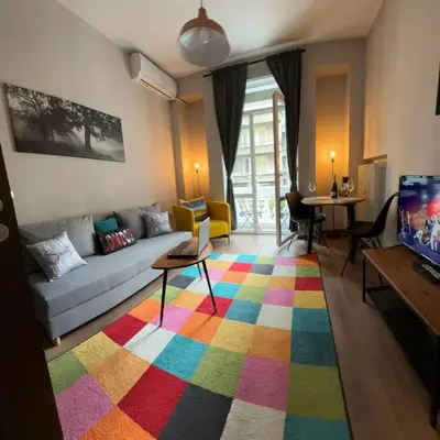 a living room with a couch and a colorful rug at Apartment top center Maria in Sofia