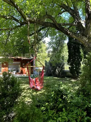 a red hammock hanging from a tree in a yard at Guest House Efrosina in Glozhene