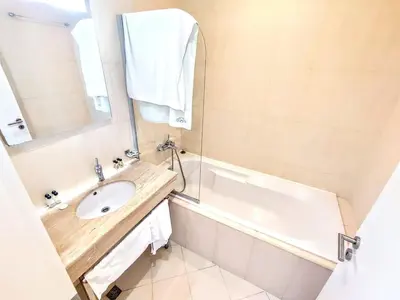 a bathroom with a sink and a tub and a mirror at Bansko LUXURY 2 bedroom apartment - SKI&SPA resort in Bansko