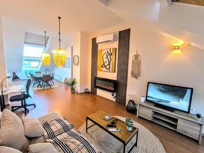 a living room with a couch and a tv at Bansko LUXURY 2 bedroom apartment - SKI&SPA resort in Bansko