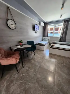 a room with a bed and a table and a clock at Continental studios 4 in Sofia