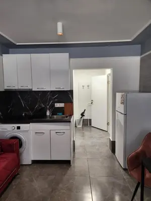 a kitchen with white cabinets and a red couch at Continental studios 4 in Sofia