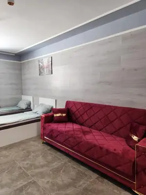 a living room with a red couch and a bed at Continental studios 4 in Sofia