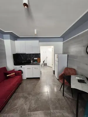 a living room with a red couch and a kitchen at Continental studios 4 in Sofia