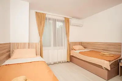 a bedroom with two beds and a window at Къща за гости Крис in Smolyan