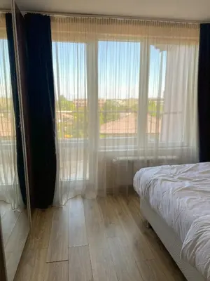 a bedroom with a bed and a large window at Paradise Nest in Sofia