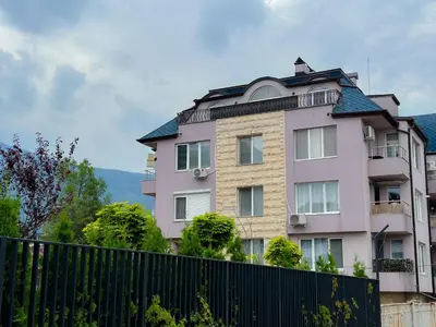 a tall pink building with a black fence at Paradise Nest in Sofia