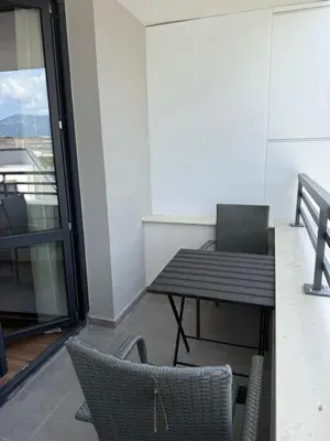 a table and chairs in a room with a balcony at Atana Home Drujba in Sofia