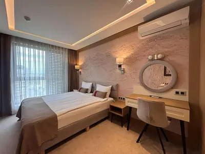 a bedroom with a bed and a desk and a mirror at MG Homes - City Park Inn in Plovdiv