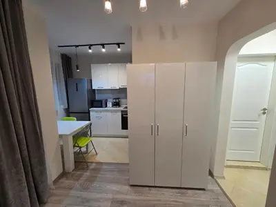 a kitchen with white cabinets and a table at Paradise Studio NBU in Sofia