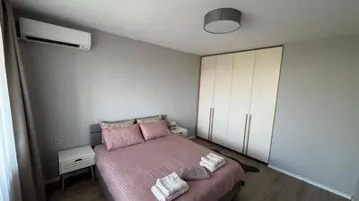 a bedroom with a pink bed and a white cabinet at Modern and cozy apartment in the city centre in Sofia