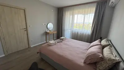 a bedroom with a large bed with a large window at Modern and cozy apartment in the city centre in Sofia