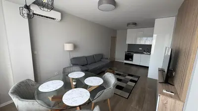 a living room with a table and chairs and a couch at Modern and cozy apartment in the city centre in Sofia