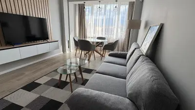 a living room with a couch and a table at Modern and cozy apartment in the city centre in Sofia