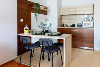a kitchen with a island with four chairs around it at Alpine Escape Bansko in Bansko