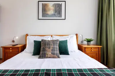a bedroom with a bed with green and white sheets at Alpine Escape Bansko in Bansko
