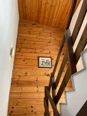a room with a wooden ceiling with a picture on the wall at Kalaydzhiev Guest House - Къща с 5 спални in Bansko