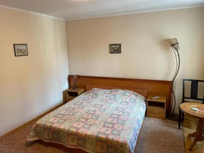 a bedroom with a bed and a lamp and a table at Kalaydzhiev Guest House - Къща с 5 спални in Bansko