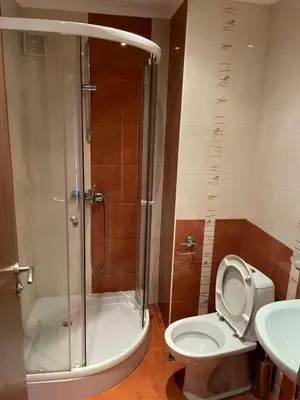 a bathroom with a shower and a toilet and a sink at Kalaydzhiev Guest House - Къща с 5 спални in Bansko