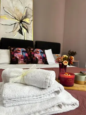 a room with two beds with towels on a table at Rea Liliya - Artistic and Inviting Nook in Sofia