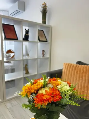 a bouquet of flowers in a vase on a table at Rea Silena - Modern and Stylish Studio in Sofia