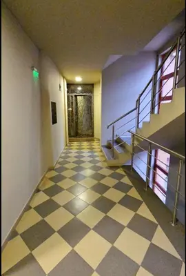 an empty hallway with a checkered floor and stairs at Guest House Amaya by novotela in Plovdiv