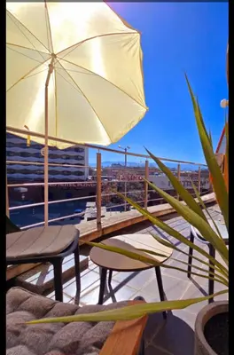 a patio with an umbrella and chairs on a balcony at Guest House Amaya by novotela in Plovdiv