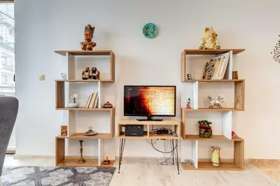 a living room with a desk with a tv and shelves at Villa Cometa Pamporovo - 1BD Near Slope #7 by Flat Manаger in Pamporovo